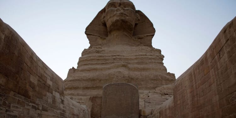 The Great Sphinx stands adjacent to the Great Pyramids of Giza following the completion of restoration work in preparation for the reopening of the courtyard around its base, in Giza, Egypt, on Nov. 9, 2014.