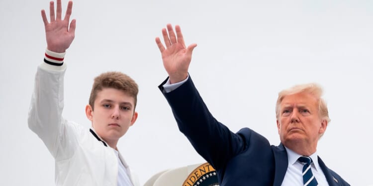 Then-President Donald Trump and his then-14-year-old son, Barron, wave as they board Air Force One at Morristown Municipal Airport in Morristown, New Jersey in an August 2020 file photo.