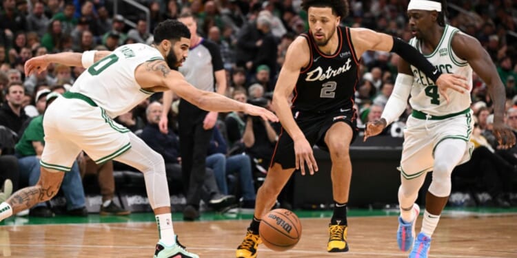 Cade Cunningham, #2 of the Detroit Pistons, drives to the basket against Jayson Tatum #0 and Jrue Holiday #4 of the Boston Celtics during the fourth quarter at Boston's TD Garden on Thursday.