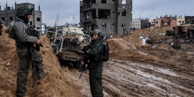 Israeli soldiers are pictured patrolling an area of the southern Gaza city of Khan Yunis in a photo taken during a media tour controlled by the Israeli military. The photo was edited under Israeli military supervision.