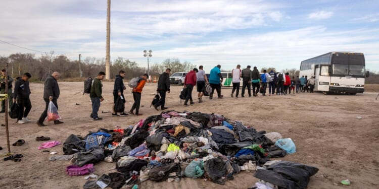 Illegal immigrants wait to load onto a U.S. Customs and Border Protection bus after crossing the U.S.-Mexico border in Eagle Pass, Texas, on Jan. 7. Over 2.3 million people have crossed illegally into the United States under the Biden Administration.