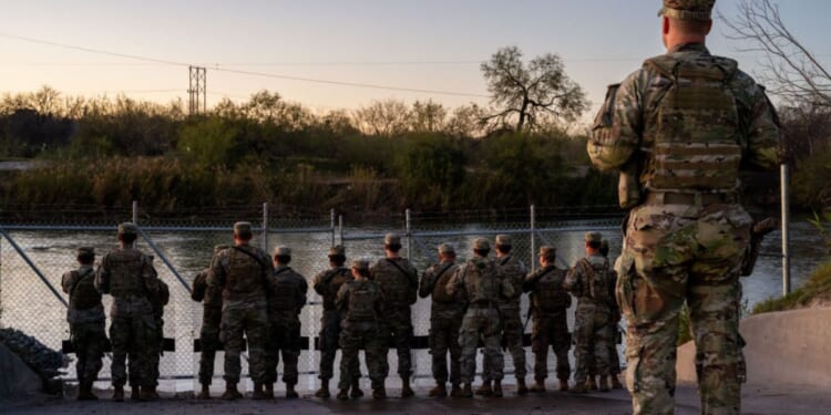 National Guard soldiers stand guard on the banks of the Rio Grande on Jan. 12 in Eagle Pass, Texas.