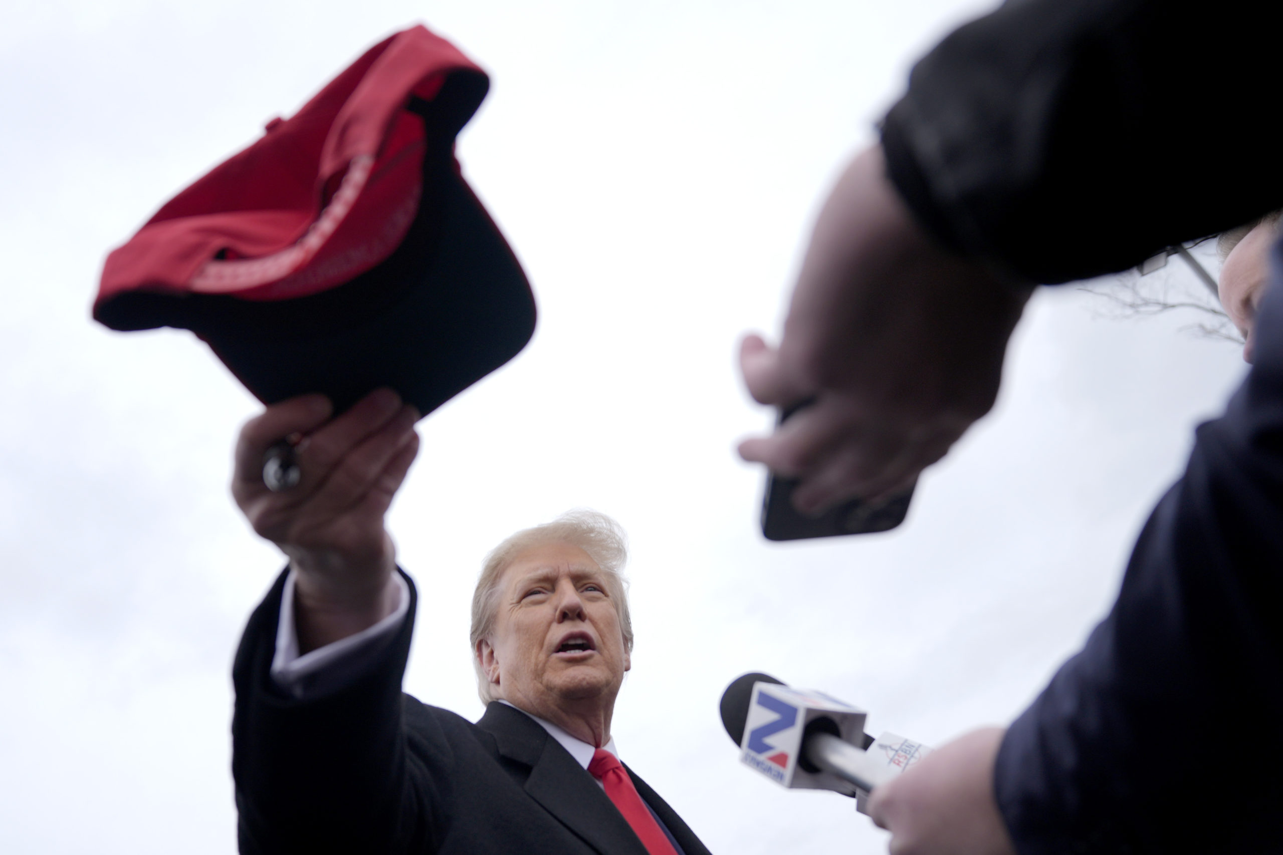 Republican presidential candidate former President Donald Trump hands off a signed hat during a campaign stop in Londonderry, New Hampshire, on Tuesday.