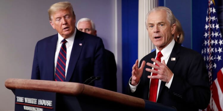 Former President Donald Trump, left, listens to former White House adviser Peter Navarro as he speaks to reporters in the James Brady Press Briefing Room in Washington, March 27, 2020.