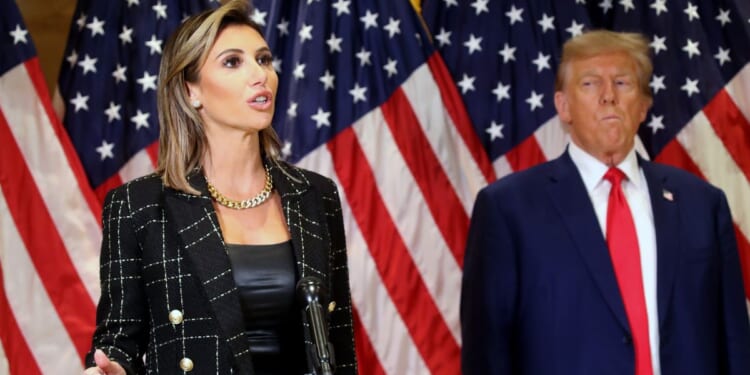 Former President Donald Trump stands with his lawyer Alina Habba as she speaks to the media following closing arguments in his civil fraud trial on Thursday in New York City.