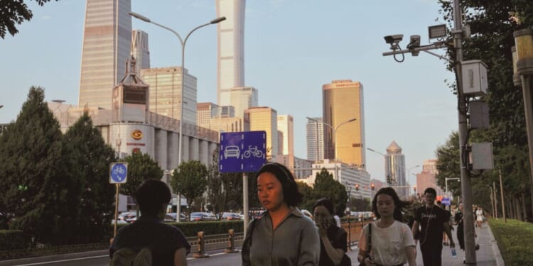 People walk near the Central Business District during the rush hour in Beijing on Aug. 14.