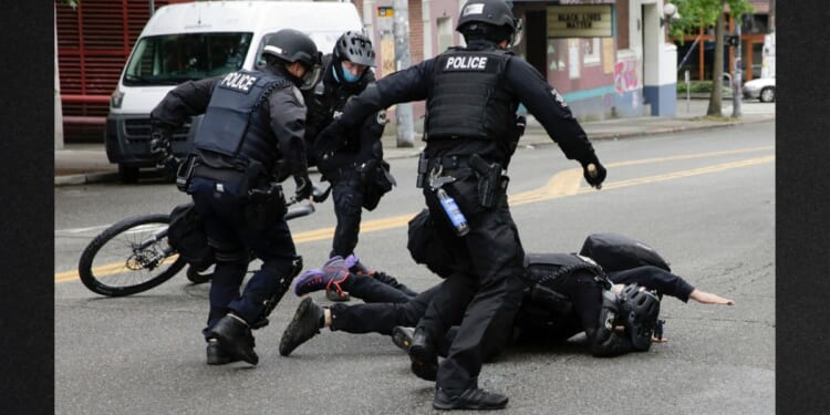 Seattle Police tackle a demonstrator who was blocking the intersection of East Pine Street and 11th Avenue after police cleared the Capitol Hill Occupied Protest and retook the department's East Precinct in Seattle, Washington on July 1, 2020.