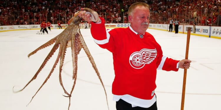 Al Sobotka, building operations manager for Olympia Entertainment, collects an octopus during a timeout at the last NHL game at Joe Louis Arena in Detroit between the New Jersey Devils and Detroit Red Wings on April 9, 2017.