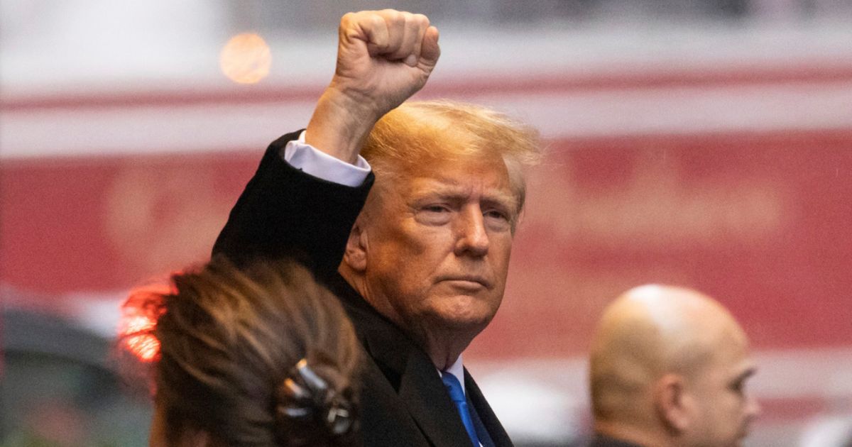 Former President Donald Trump raises his fist as he leaves his apartment building Thursday in New York.