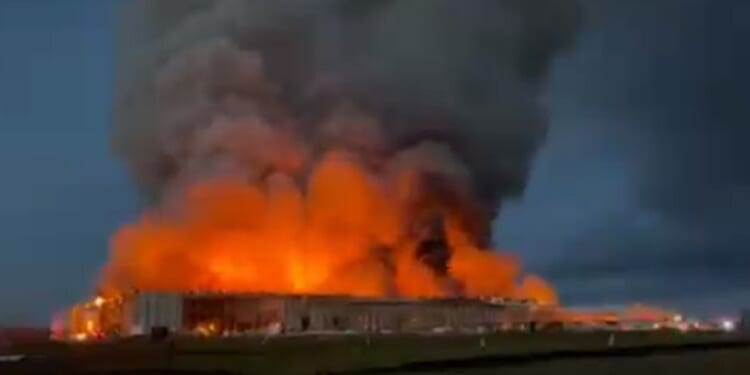 Fire engulfs buildings at a chicken farm in Kurten, Texas, on Monday.