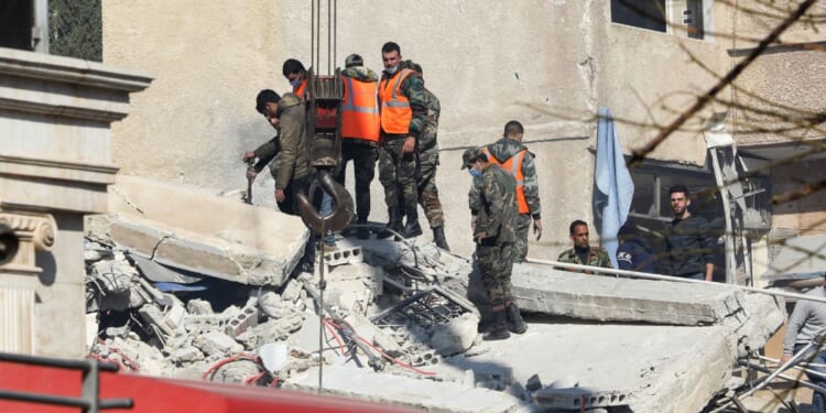 Security and emergency personnel search the rubble of a building destroyed in a reported Israeli strike in Damascus on Saturday.