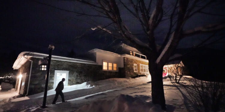 A man arrives Monday evening at the Tillotson House where six voters in the hamlet of Dixville Notch, New Hampshire, voted Tuesday in the New Hampshire Republican primary.