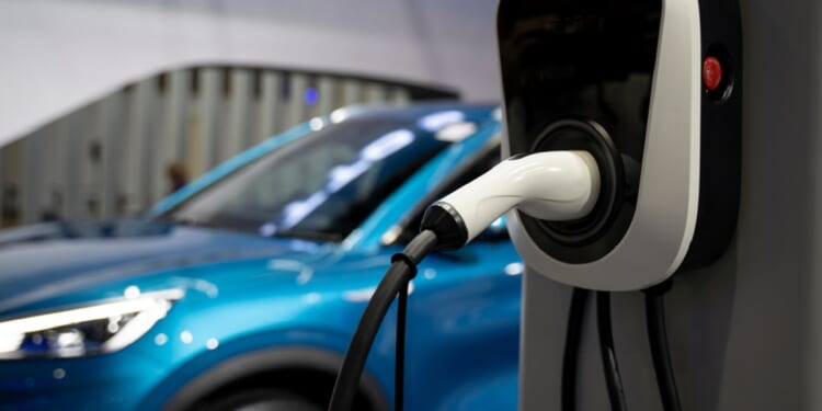 An electric vehicle charges in a stock photo