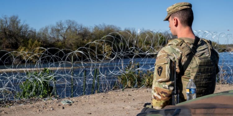 A National Guard soldier stands guard on the banks of the Rio Grande on Jan. 12 in Eagle Pass, Texas.