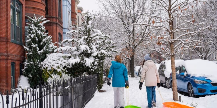 Girls walk through the snowy Capitol Hill neighborhood in Washington D.C. Friday.