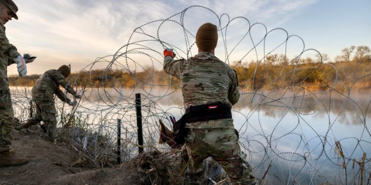 Texas National Guard soldiers install additional razor wire along the Rio Grande in Eagle Pass, Texas, on Jan. 10.