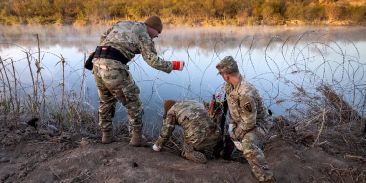 Texas National Guard soldiers install razor wire along the Rio Grande in a Jan. 10 photo.