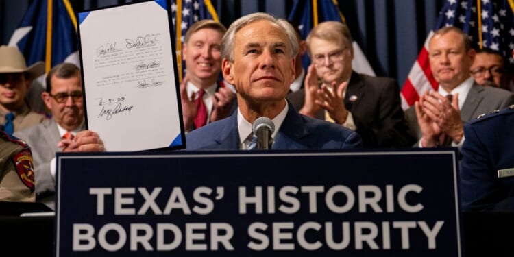 Texas Gov. Greg Abbott displays a signed bill designated towards enhancing border security along the Texas-Mexico border during a news conference at the Texas State Capitol in Austin, Texas, on June 8.