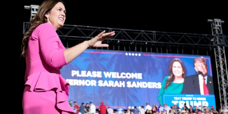 Arkansas Gov. Sarah Huckabee Sanders, walks across a stage after being introduced at a November campaign rally for former President Donald Trump in Hialeah, Florida.