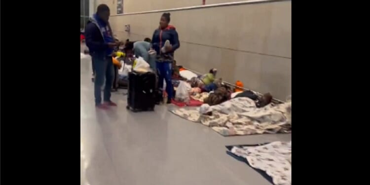 Migrant bedding is spread on the floor of a terminal at Boston's Logan International Airport.