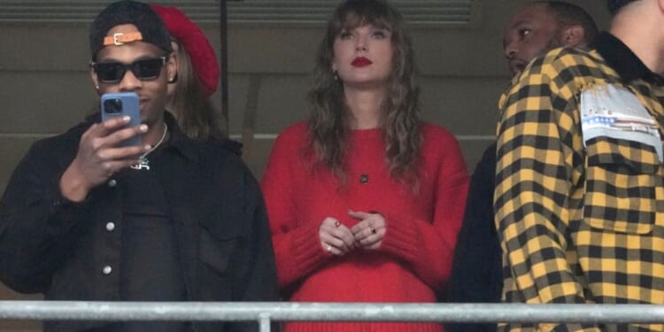 Taylor Swift, center, watches the AFC Championship NFL football game between the Baltimore Ravens and the Kansas City Chiefs, Sunday, in Baltimore.