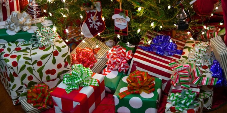 A stock photo shows wrapped presents under a Christmas tree.