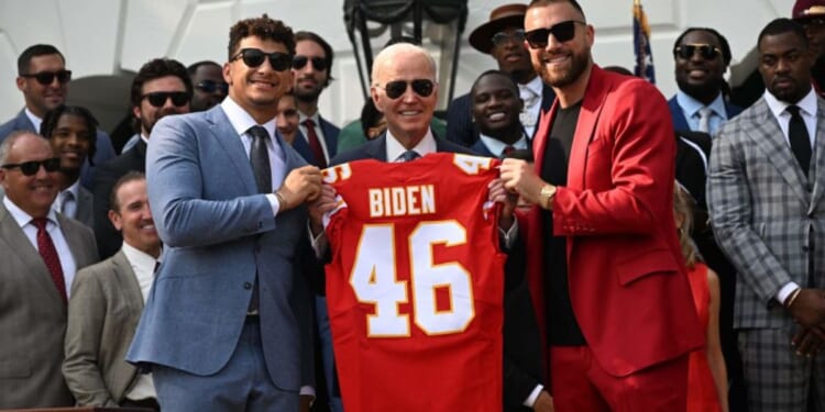 Kansas City Chiefs tight end Travis Kelce, right, and quarterback Patrick Mahomes, left, pose with President Joe Biden holding a jersey during the team's visit to the White House after winning the 2023 Super Bowl.