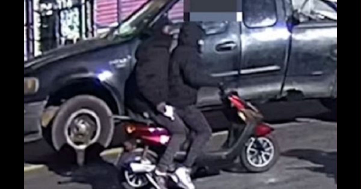 Two young men aboard a moped.