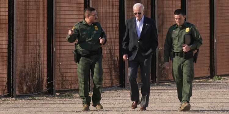 Joe Biden walks with U.S. Border Patrol agents along a stretch of the U.S.-Mexico border