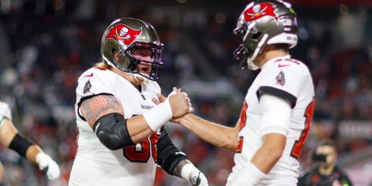 Ryan Jensen, left, and Tom Brady shake hands prior to the Tampa Bay Buccaneers' wild-card playoff game against the Dallas Cowboys at Raymond James Stadium in Tampa, Florida, on Jan. 16, 2023.