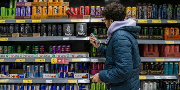 A man shops for energy drinks in a supermarket. New research suggests that energy drinks can be extremely harmful to children.