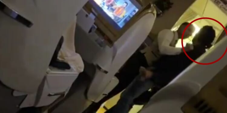 While on a flight from Dubai to Islamabad on Sunday, a male passenger, right, assaulted a flight attendant and was promptly restrained by crew members.