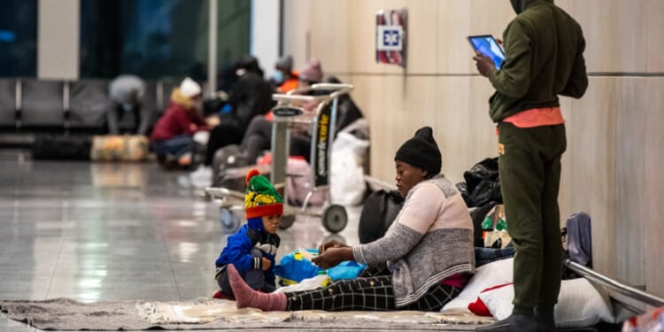 Migrant families are pictured in Boston's Logan International Airport in a Jan. 30 file photo. Private families in Massachusetts are being asked to open their homes to migrants as the state's shelter system is swamped.