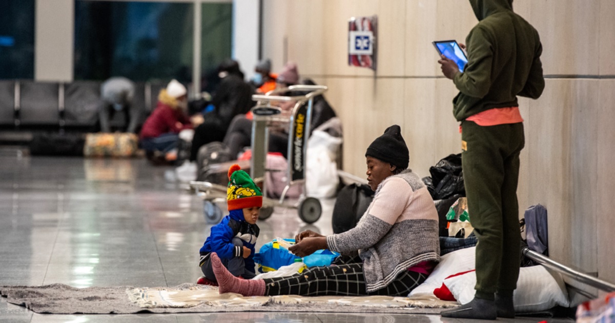 Migrant families are pictured in Boston's Logan International Airport in a Jan. 30 file photo. Private families in Massachusetts are being asked to open their homes to migrants as the state's shelter system is swamped.