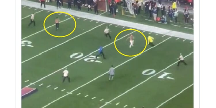 Two men are corralled by security after rushing the field Sunday night at the Super Bowl in Las Vegas.