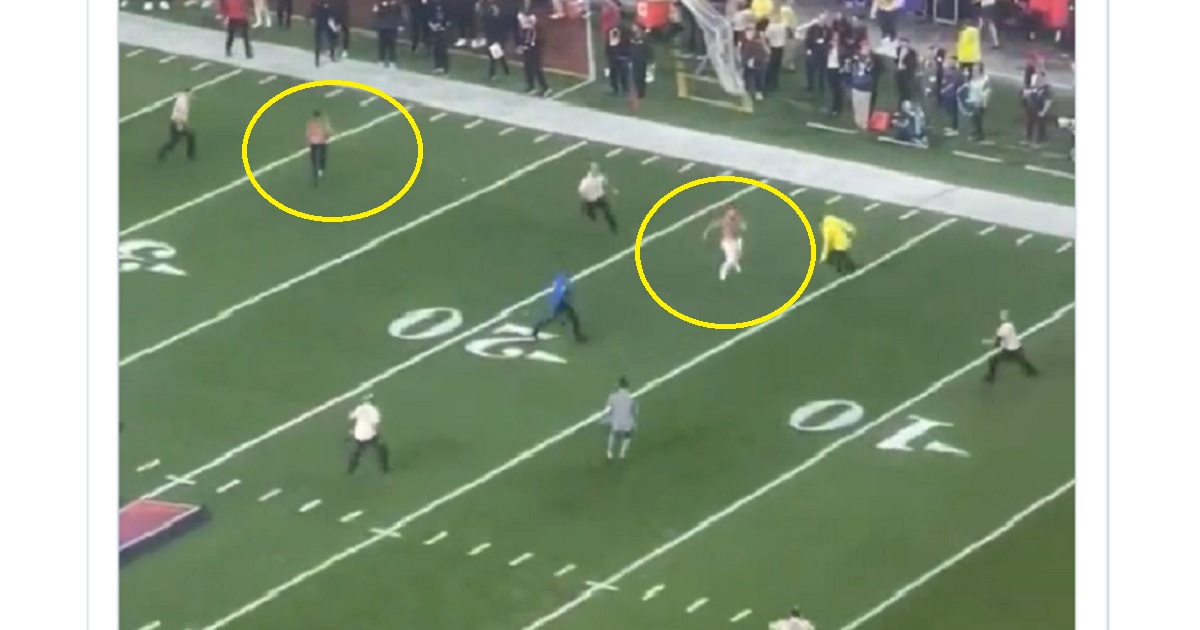 Two men are corralled by security after rushing the field Sunday night at the Super Bowl in Las Vegas.