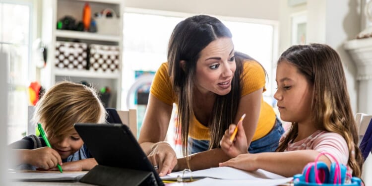 A stock photo shows a mom teaching her children at home. Michigan homeschoolers are gearing up to fight the state's plan to register their kids.