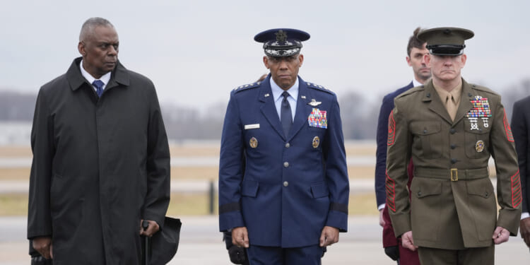 Defense Secretary Lloyd Austin, Chairman of the Joint Chiefs of Staff Gen. Charles Q. Brown, and Marine Corps. Sgt. Maj. Troy E. Black watch as an Army carry team moves the flag-draped transfer case containing the remains of U.S. Army Sgt. Kennedy Ladon Sanders, 24, of Waycross, Georgia, during a casualty return at Dover Air Force Base in Delaware on Friday. Sanders was killed in a drone attack in Jordan on Sunday.