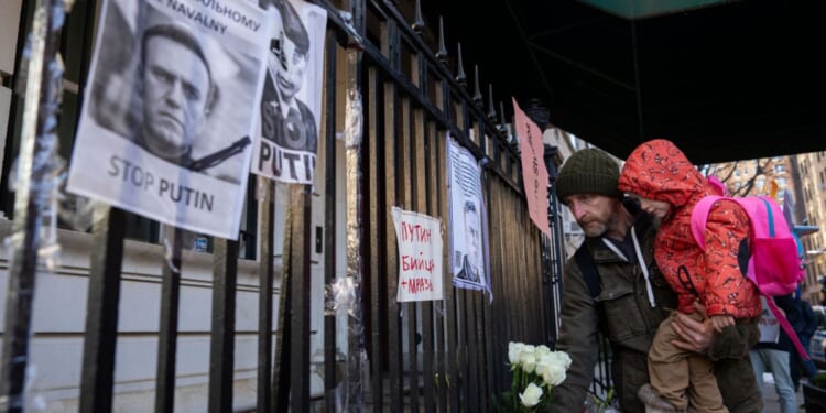 People leave flowers as they attend a memorial for Vladimir Putin critic Alexei Navalny at the Russian Consulate in New York City on Friday.