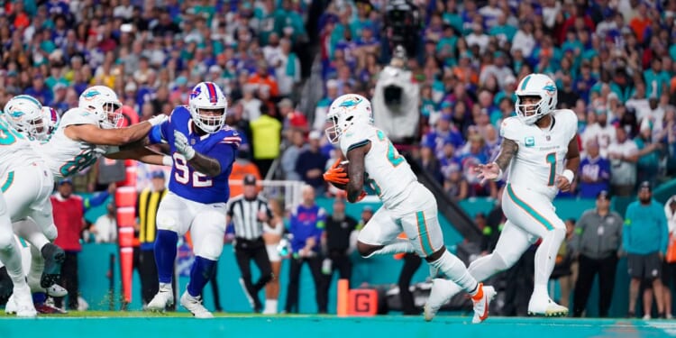 Tua Tagovailoa of the Miami Dolphins hands off to De'Von Achane during a game against the Buffalo Bills at Hard Rock Stadium in Miami Gardens, Florida, on Jan. 7.