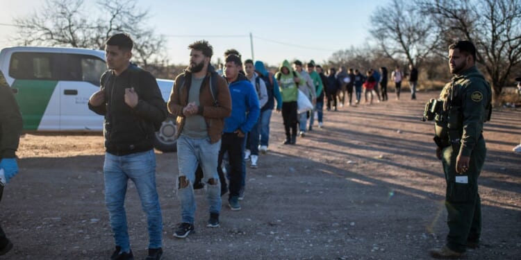 A group of illegal migrants are processed by Border Patrol on Sunday outside Eagle Pass, Texas.