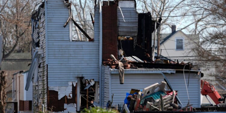 A home destroyed by from fire is shown in East Lansdowne, Pennsylvania, , Thursday. Authorities were searching the charred remains of the suburban Philadelphia home Thursday morning, a day after a shootout and fire left two police officers wounded and at least six people unaccounted for.