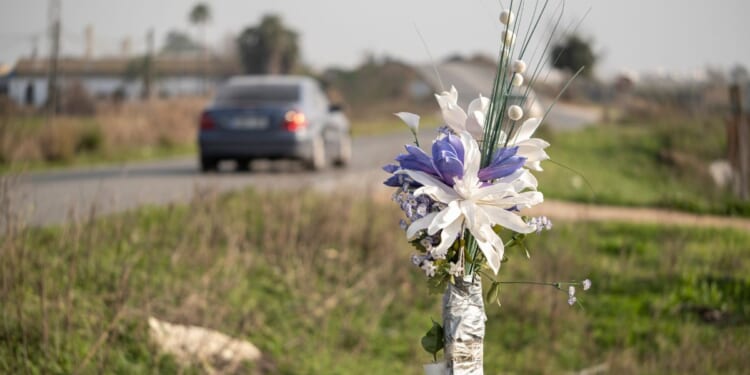 A stock photo shows a bouquet set up as a roadside memorial at the site of a fatal crash.