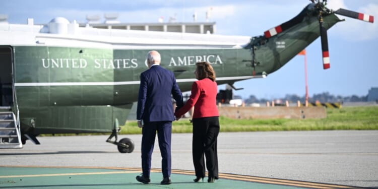 President Joe Biden walks hand-in-hand with Rep. Nancy Pelosi at San Francisco International Airport in California on Wednesday.