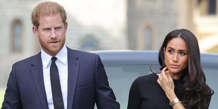 Prince Harry, Duke of Sussex, and Meghan, Duchess of Sussex, arrive on the long walk at Windsor Castle to view flowers and tributes to Queen Elizabeth II on Sept. 10, 2022.