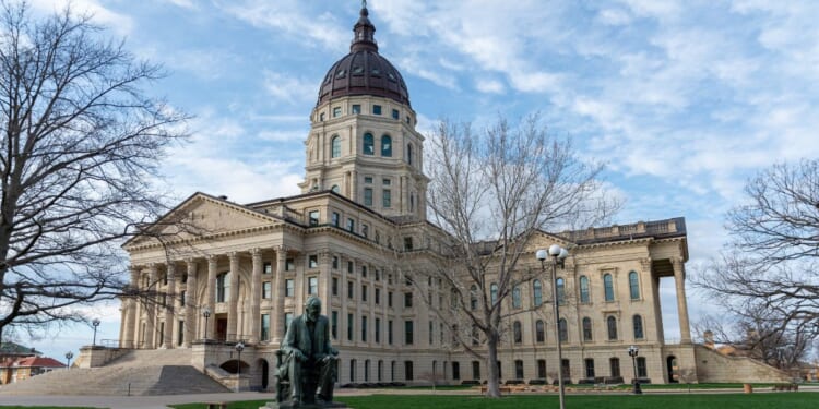 A stock photo shows the Kansas state Capitol, with a statue of Abraham Lincoln in the foreground, in Topeka on March 27, 2021.