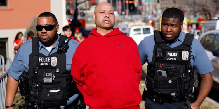 A man is detained by law enforcement following a shooting at Union Station during the Kansas City Chiefs Super Bowl victory parade on Wednesday.