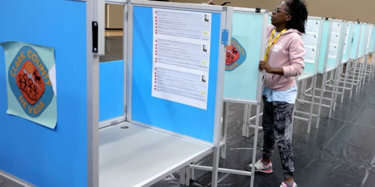 A Clark County Election Department worker sets up voting machine booths at a polling place in Las Vegas, Nevada, on Oct. 21, 2022.