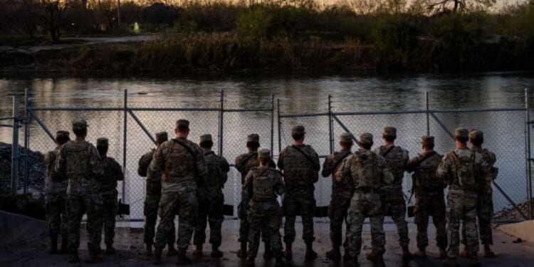 Texas National Guard soldiers stand guard on the banks of the Rio Grande river at Shelby Park in Eagle Pass, Texas, on Jan. 12.