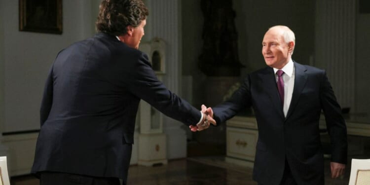 Former Fox News host Tucker Carlson, left, shakes hands with Russian President Vladimir Putin, at the Kremlin in Moscow, Russia, Tuesday.